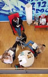 3 Jugendliche sitzen an einem Tisch.