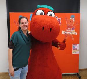 Bibliotheksmitarbeiterin mit dem lebensgroßen Drachen Kokosnuss.