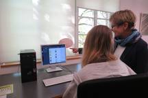 Einer Person wird was am Computerbildschirm erklärt